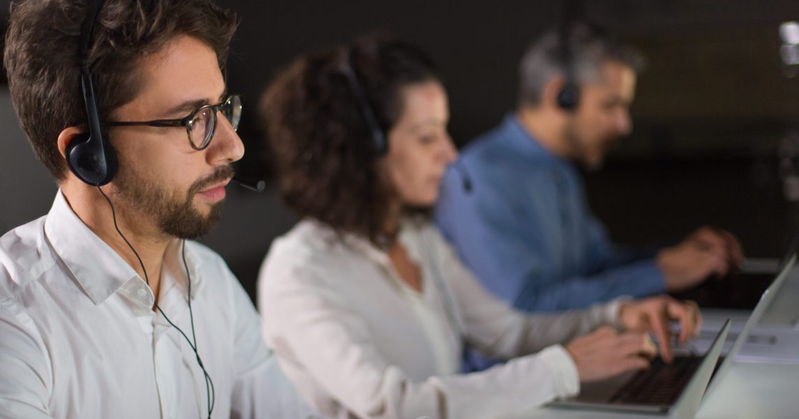 Concentrated bearded call center operator working. Thoughtful call center operators during working process. Call center concept